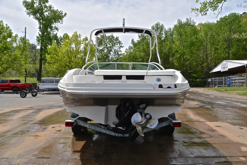 Slide: The Image of 2005 Sea Ray 220 Select boat on trailer, surrounded by trees and parked vehicles. - 12