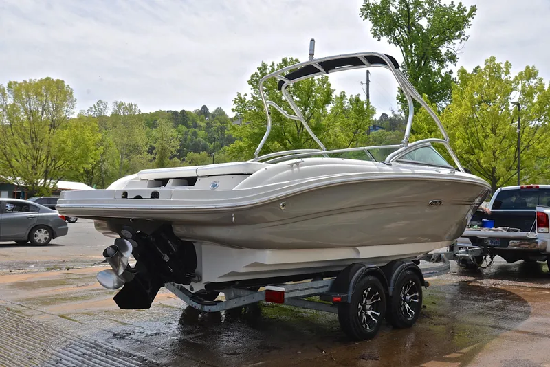 Slide: The Image of 2005 Sea Ray 220 Select boat on trailer, parked outdoors with trees in background. - 13