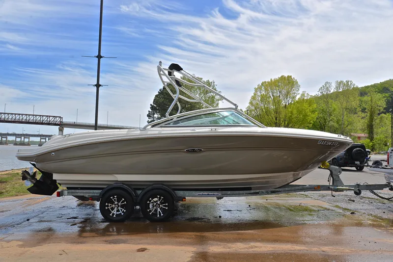 Slide: The Image of 2005 Sea Ray 220 Select boat on trailer by riverside, under a clear sky. - 14