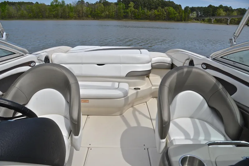 Slide: The Image of 2005 Sea Ray 220 Select boat interior with white and gray seating, on a calm lake. - 21