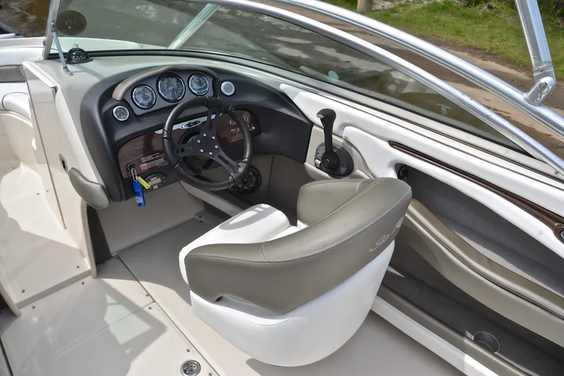 Slide: The Image of 2005 Sea Ray 220 Select boat interior with steering wheel and dashboard controls. - 23