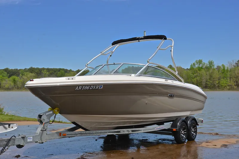 Slide: The Image of 2005 Sea Ray 220 Select boat on trailer by a lake, clear sky background. - 9