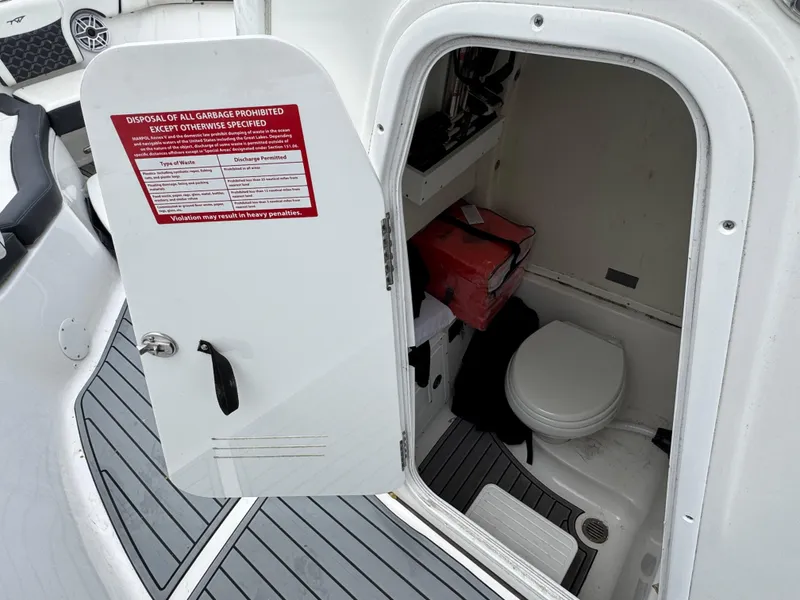 Slide: The Image of 2022 Tidewater 292 CC Adventure boat interior with open door revealing compact bathroom. - 18