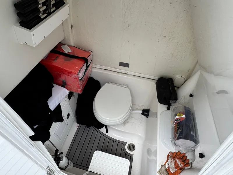 Slide: The Image of Compact bathroom in 2022 Tidewater 292 CC Adventure boat with toilet and storage. - 19