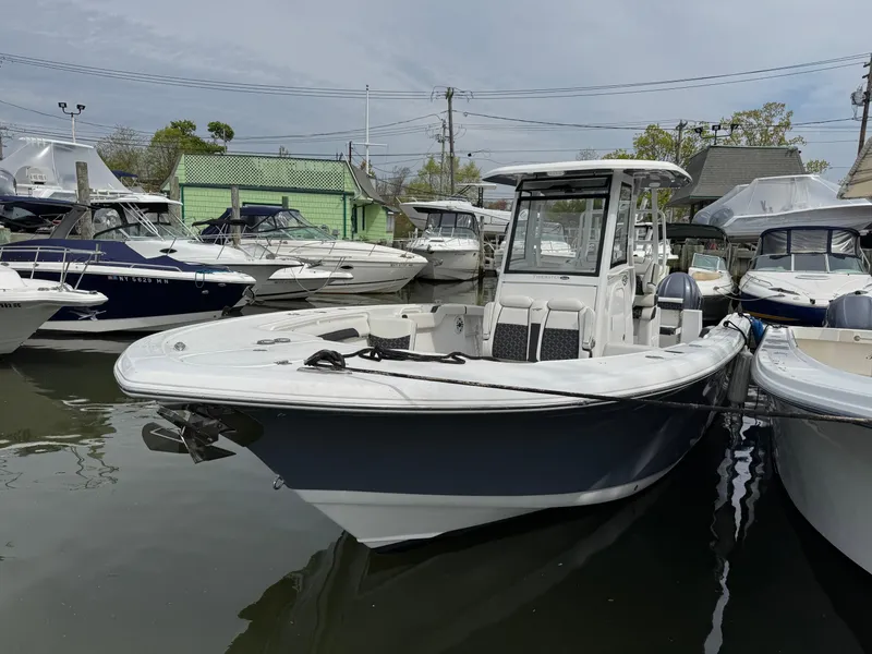 Slide: The Image of 2022 Tidewater 292 CC Adventure boat docked among other vessels. - 2