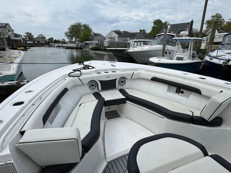 Slide: The Image of 2022 Tidewater 292 CC Adventure boat with spacious seating, docked in a serene waterfront setting. - 20