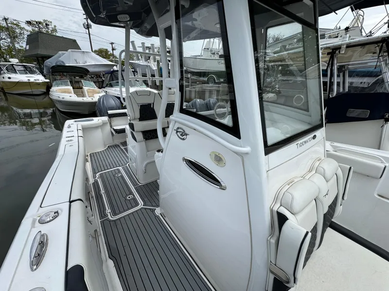 Slide: The Image of 2022 Tidewater 292 CC Adventure boat, sleek design, spacious deck, marina setting. - 24