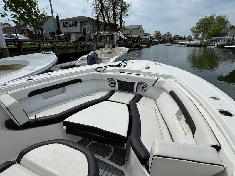 Slide: The Image of 2022 Tidewater 292 CC Adventure boat with spacious seating, docked in a serene canal setting. - 27