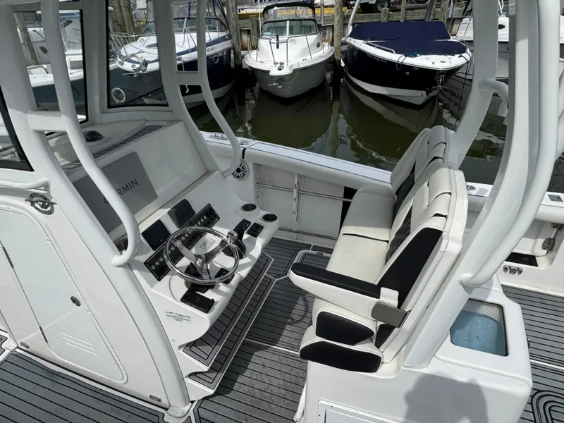 Slide: The Image of 2022 Tidewater 292 CC Adventure boat interior with helm and seating area. - 3