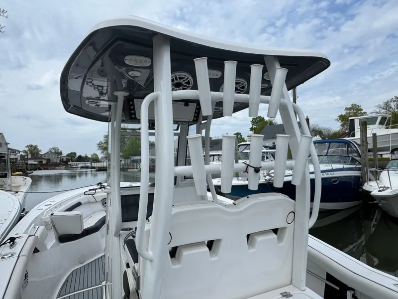Slide: The Image of 2022 Tidewater 292 CC Adventure boat with rod holders, docked by a serene waterfront. - 7