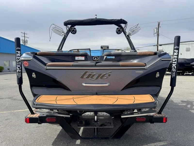 Slide: The Image of 2018 Tigé R21 boat rear view with Prestige trailer in parking lot. - 5
