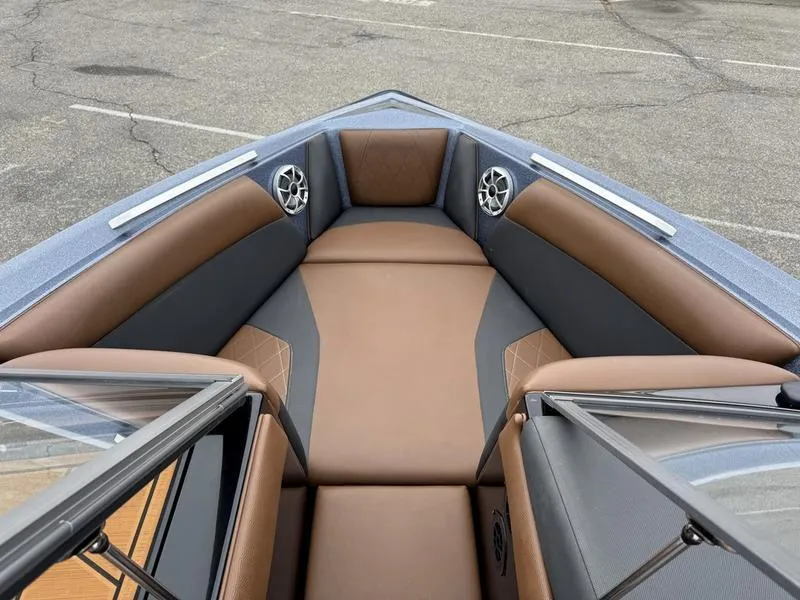 Slide: The Image of 2018 Tigé R21 boat interior with brown and gray seating, featuring built-in speakers. - 9