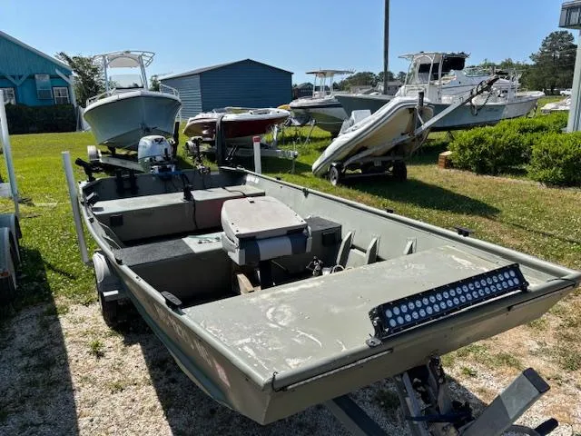 Slide: The Image of 2016 Crestliner CR 1448T boat on trailer, parked outdoors with other boats nearby. - 0