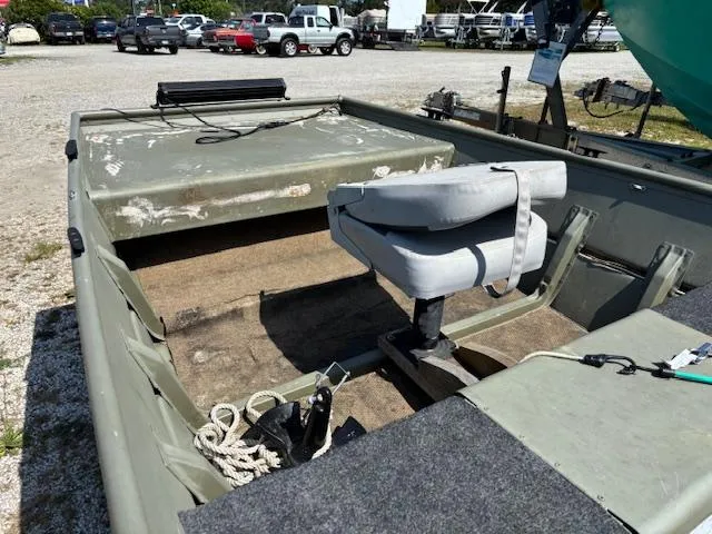 Slide: The Image of 2016 Crestliner CR 1448T boat interior with seating and storage, parked outdoors. - 11