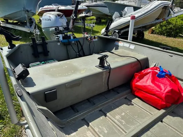 Slide: The Image of 2016 Crestliner CR 1448T boat interior with motor and red bag on deck. - 12
