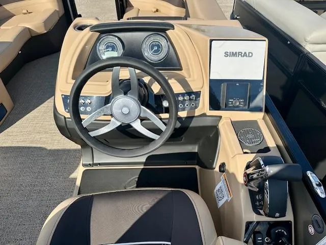 Slide: The Image of 2025 Barletta C24UE boat dashboard with steering wheel and Simrad display. - 5