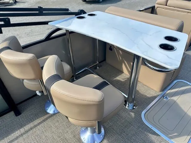 Slide: The Image of 2025 Barletta C24UE boat interior with beige seating and a sleek white table. - 7
