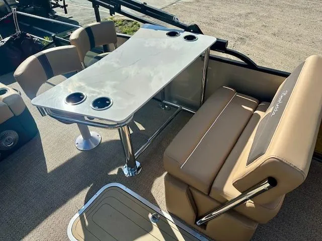 Slide: The Image of 2025 Barletta C24UE boat interior with beige seating and table with cup holders. - 8