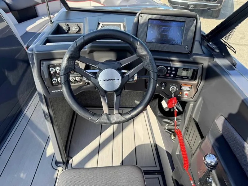 Slide: The Image of 2021 Moomba Craz boat dashboard with steering wheel and control panel. - 11