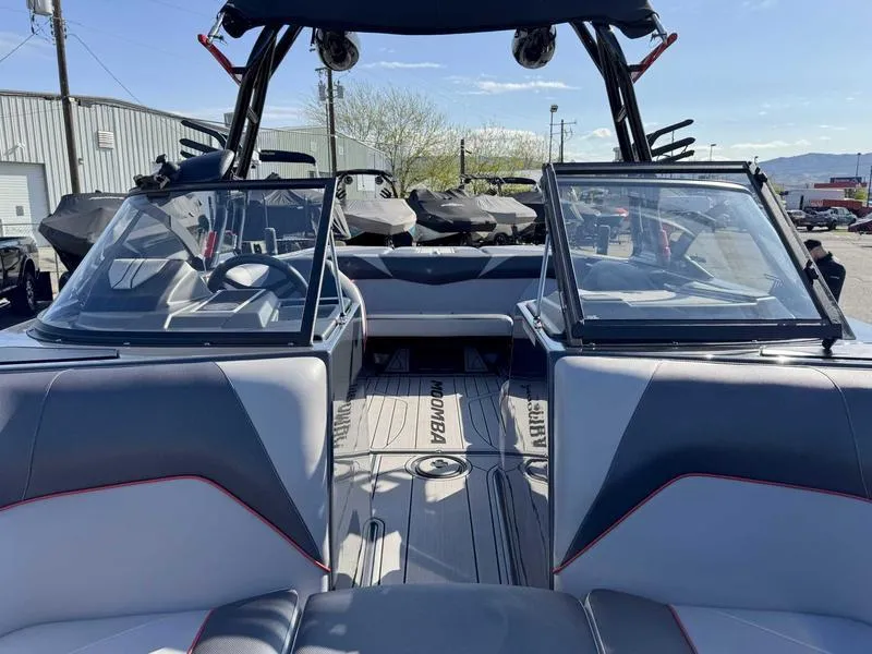 Slide: The Image of 2021 Moomba Craz boat interior with dual windshields and seating, parked outdoors. - 13