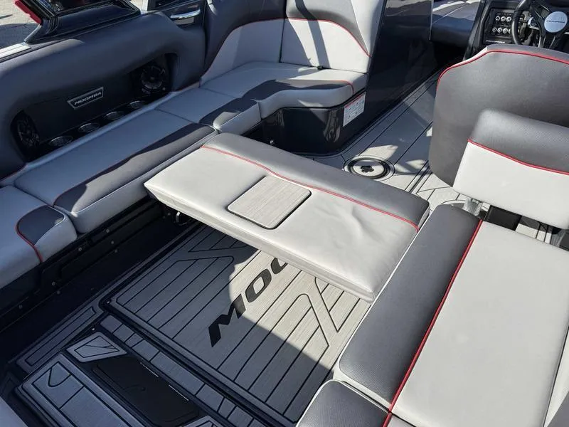 Slide: The Image of 2021 Moomba Craz boat interior with gray seating and red accents. - 14