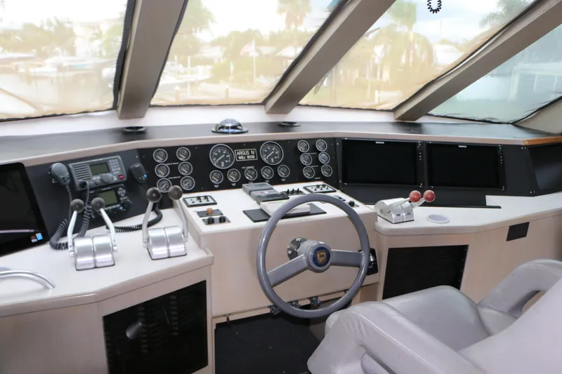 Slide: The Image of Cockpit of a 1990 Donzi 65 yacht with steering wheel and control panels. - 16
