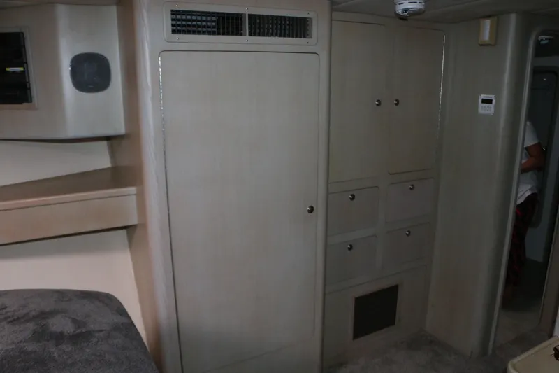 Slide: The Image of 1990 Donzi 65 interior with beige cabinetry and storage compartments. - 19