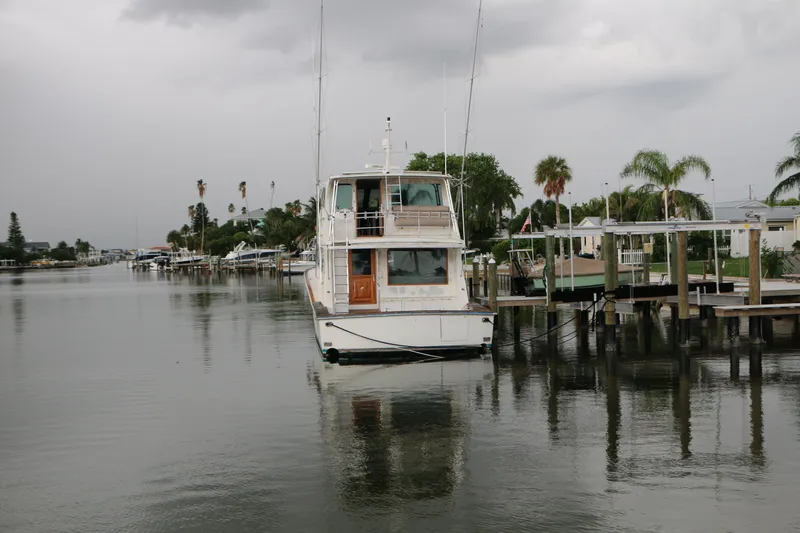 Slide: The Image of 1990 Donzi 65 yacht docked in a calm, tropical marina setting. - 2