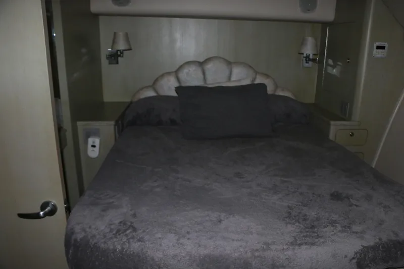 Slide: The Image of Cozy bedroom interior on a 1990 Donzi 65 yacht with plush bedding and wall lamps. - 21