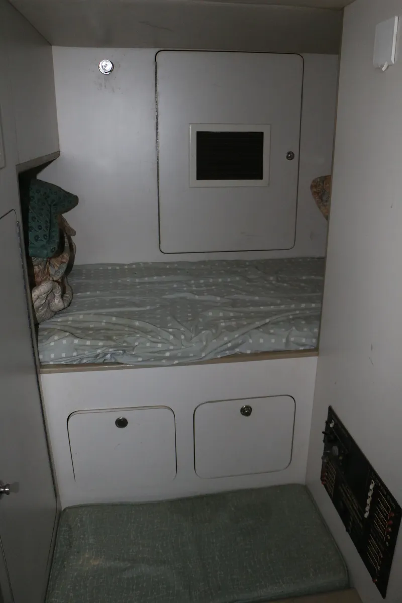 Slide: The Image of 1990 Donzi 65 cabin interior with bed, storage, and compact design. - 23