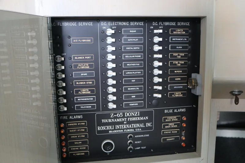 Slide: The Image of Control panel of a 1990 Donzi 65 boat, featuring various electronic and service switches. - 26