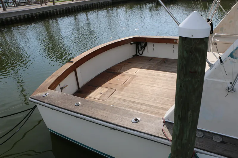 Slide: The Image of 1990 Donzi 65 boat deck with wooden finish, docked in calm waters. - 3