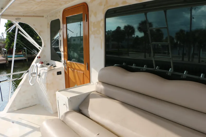 Slide: The Image of 1990 Donzi 65 yacht interior with beige seating and wooden door. - 5