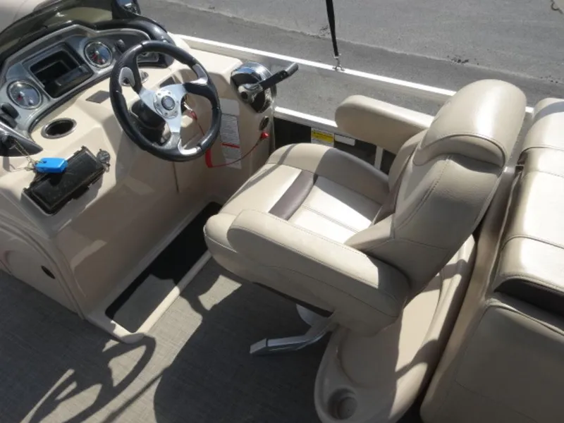Slide: The Image of Captain's seat and helm of 2018 Sun Tracker 24XP3 pontoon boat, featuring beige upholstery. - 10
