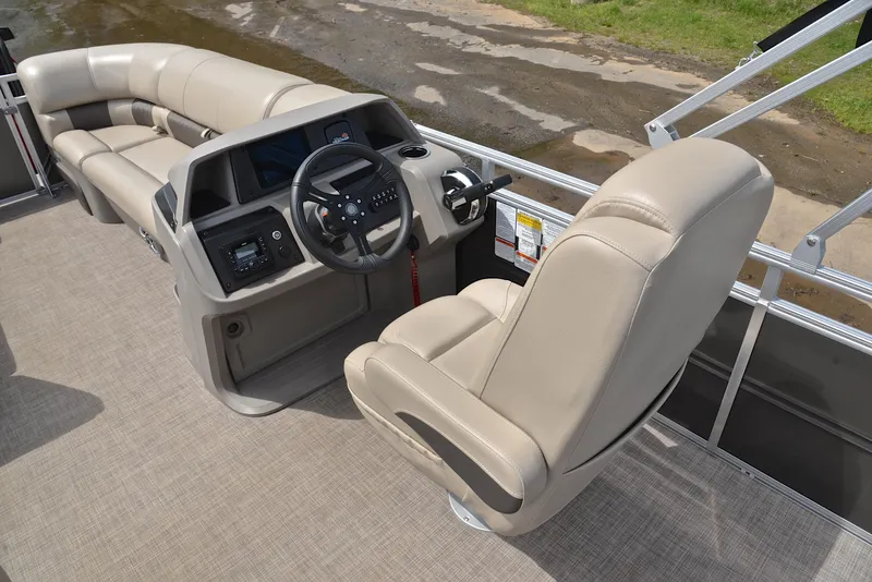 Slide: The Image of 2024 Sun Tracker Party Barge 20 DLX interior with beige seating and steering console. - 26