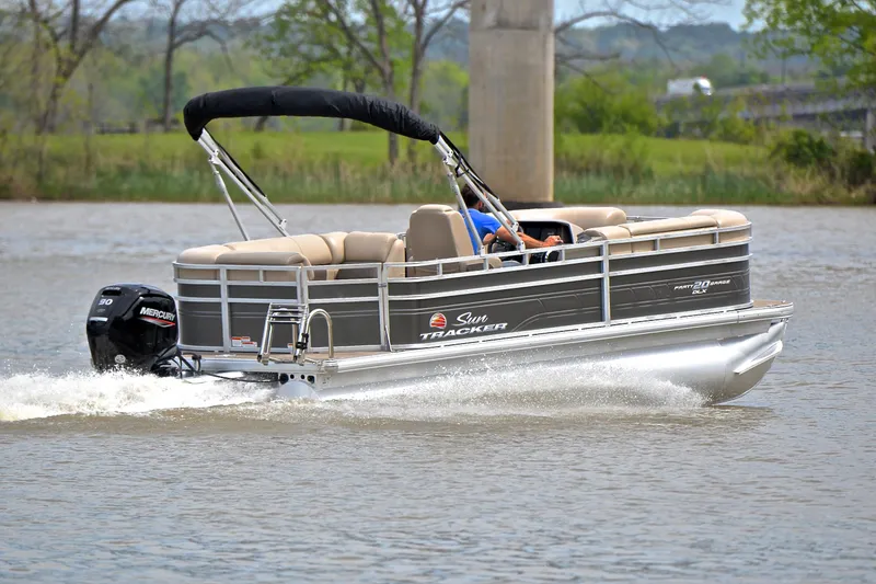 Slide: The Image of 2024 Sun Tracker Party Barge 20 DLX pontoon boat cruising on a lake. - 5