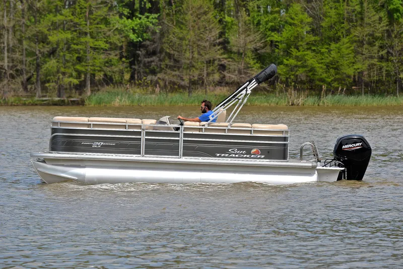 Slide: The Image of 2024 Sun Tracker Party Barge 20 DLX pontoon boat cruising on a lake. - 8