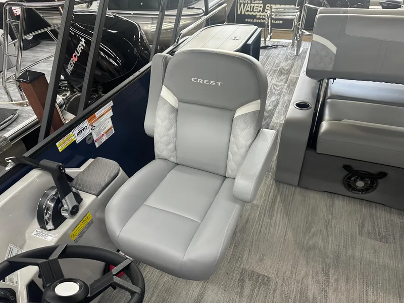 Slide: The Image of 2025 Crest Classic 220 boat interior with gray captain's chair and steering wheel. - 7