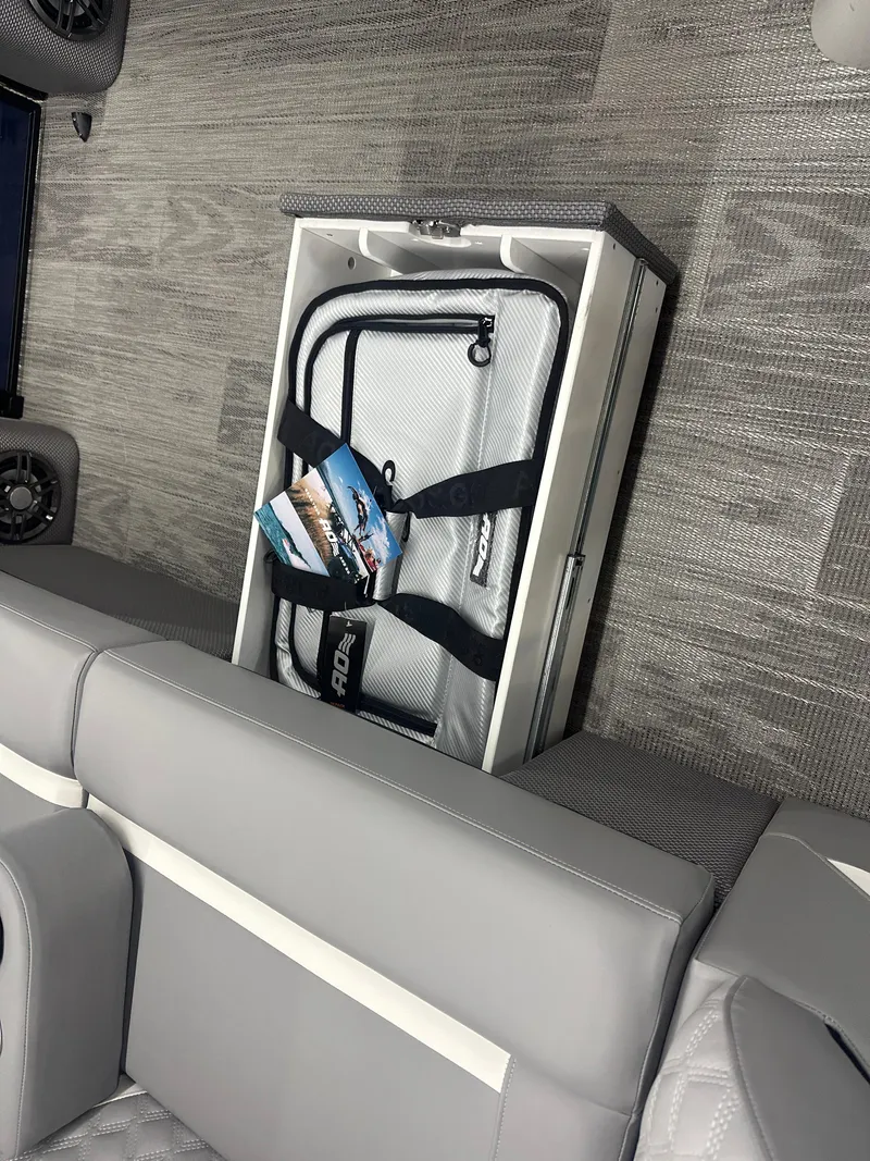 Slide: The Image of 2025 Crest Classic 220 interior with gray seating and storage compartment. - 9