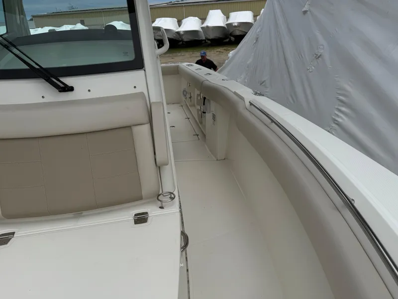 Slide: The Image of 2017 Boston Whaler 280 Outrage boat interior with beige seating and storage compartments. - 10