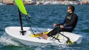 Slide: The Image of Man sailing 2023 RS Zest boat on open water, wearing a wetsuit. - 0