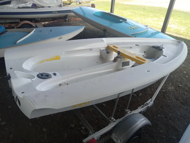 Slide: The Image of 2023 RS Zest sailboat on trailer, white hull, stored outdoors. - 3