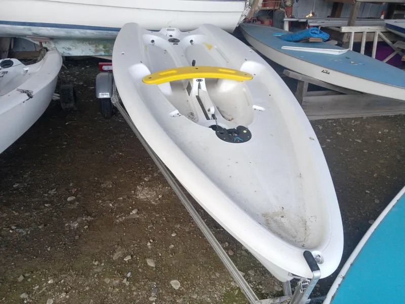 Slide: The Image of 2023 RS Zest sailboat on trailer, white hull with yellow accents, parked outdoors. - 4