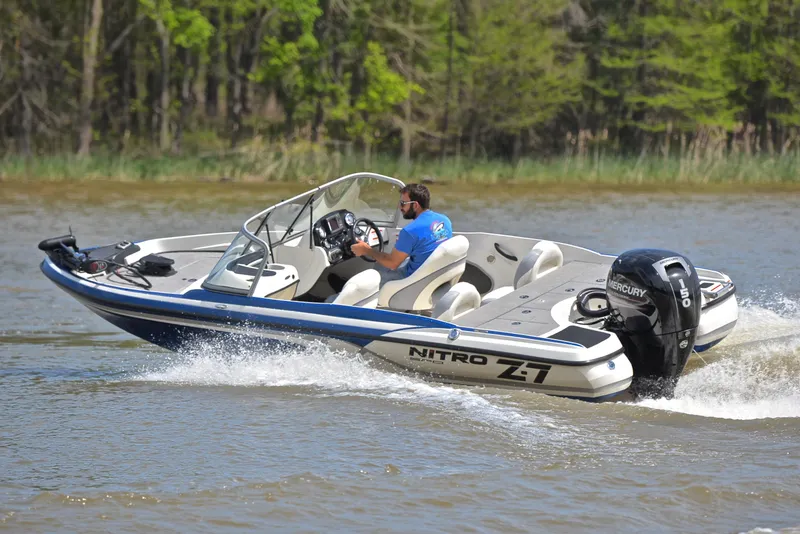 Slide: The Image of 2016 Nitro Z-7 Sport boat cruising on a lake with lush green trees in the background. - 6