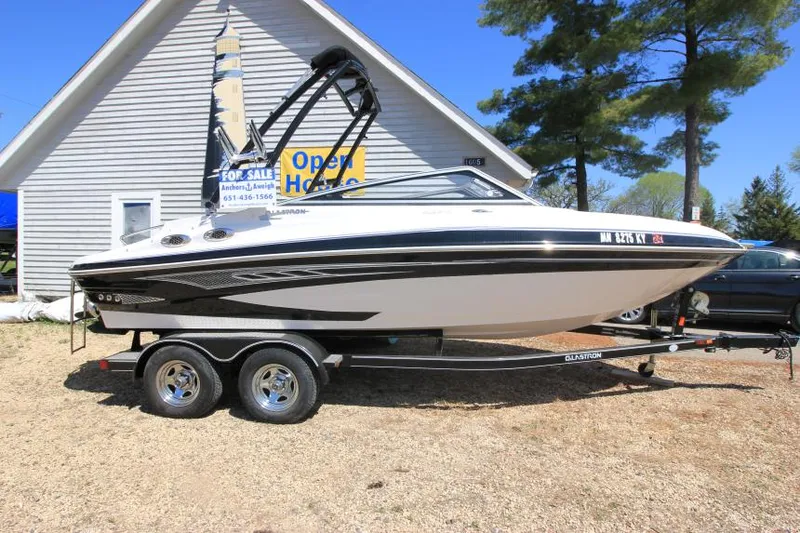 Slide: The Image of 2011 Glastron GLS 215 boat on trailer, parked outside a building. - 1