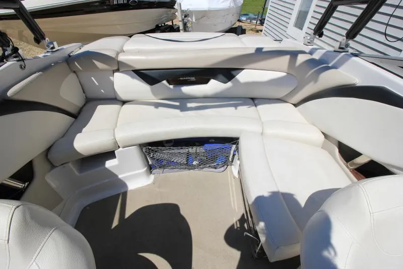 Slide: The Image of 2011 Glastron GLS 215 boat interior with white seating and storage net. - 11