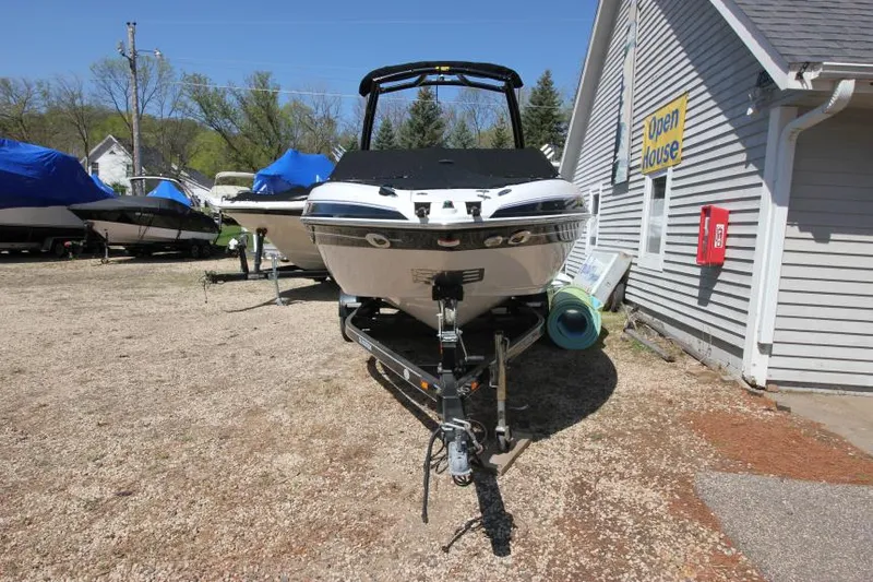Slide: The Image of 2011 Glastron GLS 215 boat on trailer near a building, outdoor setting. - 3