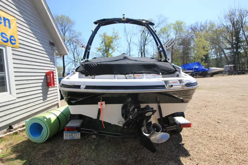 Slide: The Image of 2011 Glastron GLS 215 boat parked outdoors near a building. - 7