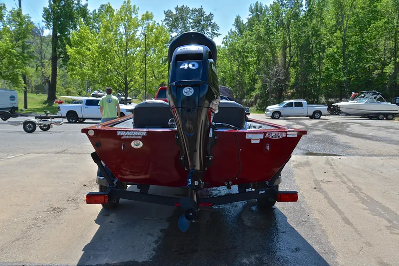 Slide: The Image of 2019 Bass Tracker Pro 170 boat on trailer, parked outdoors with trees in background. - 13