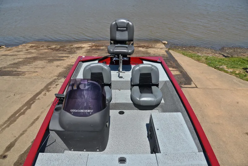 Slide: The Image of 2019 Bass Tracker Pro 170 boat with seating, docked by a lake. - 21
